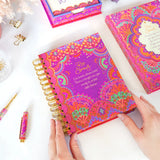Colorful spiral-bound notebook with decorative cover on a white surface