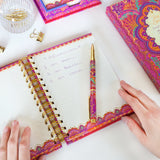 Colorful planner with a pen on a white surface