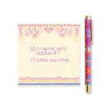 Notebook with floral border and pen on a white background