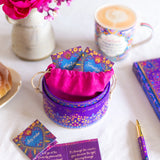 Colorful gift box with cards and a cup of coffee on a table