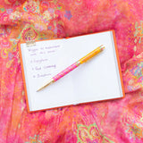 Notebook with a list of vegetables on a colorful fabric background