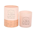 Pink candle with 'Life is Better with Cats' text and cat illustrations, next to its packaging.