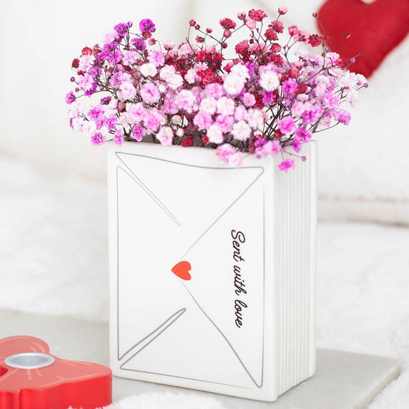 White envelope-shaped vase with pink and red flowers and 'Sent with love' text on a white background.