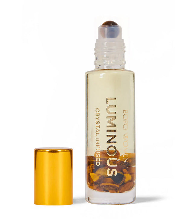 Luminous crystal-infused roller bottle with gold cap on a white background