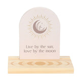 Decorative item with a moon and sun design and text 'Live by the sun, love by the moon' on a white background.