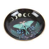 Decorative plate with a butterfly and moon phases design on a black background