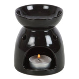 Black ceramic oil burner with a lit tealight candle on a white background