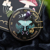 Decorative compass with butterfly design and gemstones on a dark fabric background