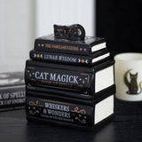 Decorative book stack with a cat figurine on top, themed around cats and magic.