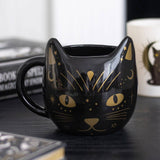 Black cat-shaped mug with gold details on a surface