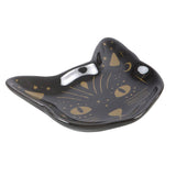 Black cat-shaped dish with gold designs on a white background