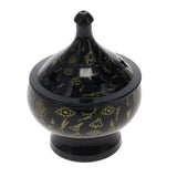 Black incense burner with gold designs on a white background