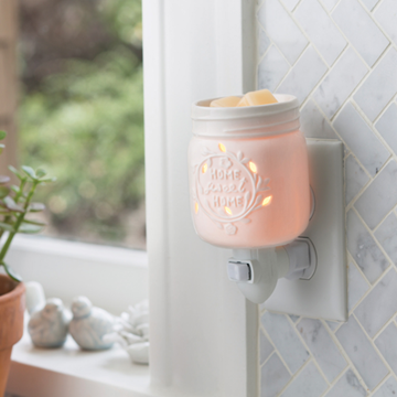 Pink wax warmer on a wall with a blurred background