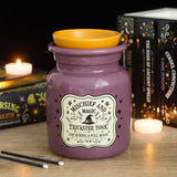 Purple jar labeled 'Mischief and Magic Trickster Tonic' with yellow lid on a wooden surface.