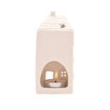White ceramic lantern with a lit tealight candle inside on a white background
