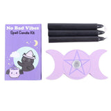 Spell candle kit with black candles, a purple card, and a purple pentacle symbol on a white background