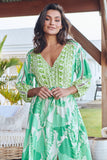 Woman wearing a green and white patterned dress outdoors