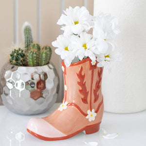 Decorative boot with flowers and a cactus in the background