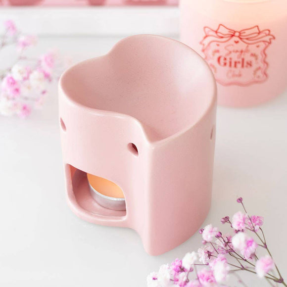 Heart-shaped pink oil burner with flowers on a light background