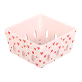 Pink storage basket with red heart pattern on a white background