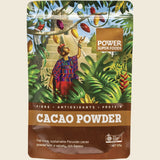Power Super Foods Cacao Powder package with a tropical design and person in a colorful shirt.