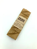 A chunky incense plank wrapped in brown paper with a label that reads 'TRIBE EARTH Australian Premium Sandalwood & Vetiver Grass Incense'.