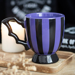 Purple and black striped mug on a wooden surface with a blurred background