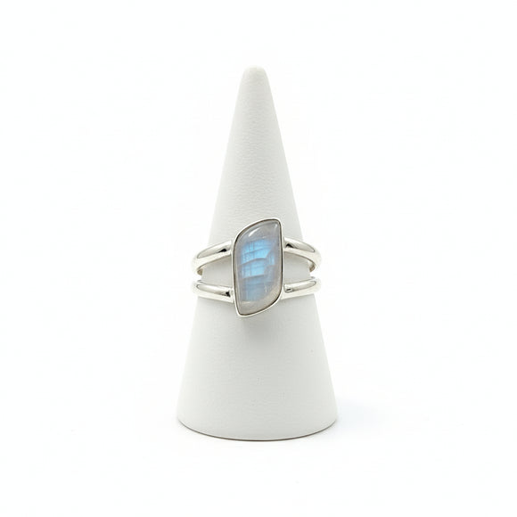 Silver ring with a blue gemstone on a white cone stand