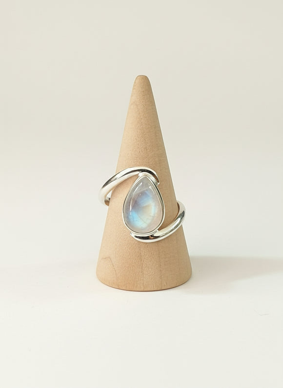 teardrop-shaped gemstone on a wooden cone against a white background