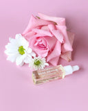 Rose Revival skincare product with a pink rose and white flowers on a pink background