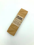 A handcrafted incense plank made from sandalwood and rose, branded by Tribe Earth, packaged in a brown paper sleeve with a label.