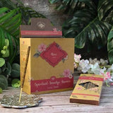 Rose incense packaging with incense sticks on a wooden surface with greenery in the background
