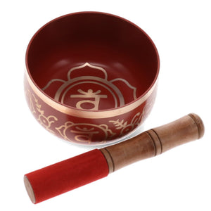 Red singing bowl with decorative patterns and a wooden mallet on a white background