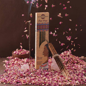 Incense packaging with incense sticks on a dark background with rose petals