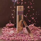 Incense packaging with incense sticks on a dark background with rose petals