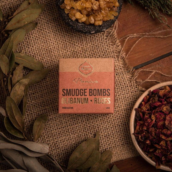 Box of smudge bombs with herbs and leaves on a textured surface