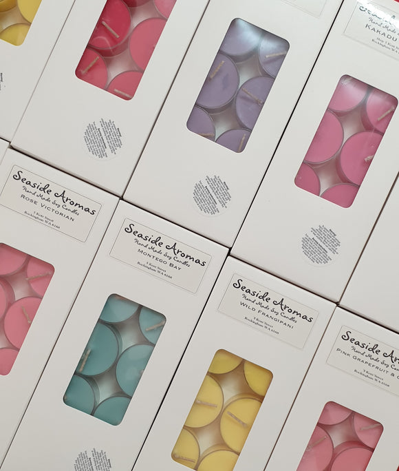 Boxes of Seaside Aromas candles with colorful tealights visible through clear panels.