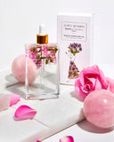 BOPO Women's body oil bottle with packaging and pink roses on a white background