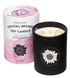 Black candle with sunflower design next to a pink and white candle container on a white background