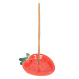 Strawberry-shaped incense holder with a single incense stick on a white background