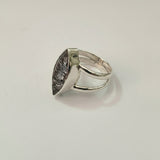 Silver ring with a textured stone on a light gray background