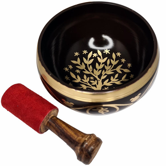 Decorative singing bowl with gold leaf design and a red mallet on a white background