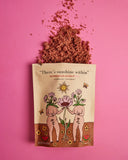 Product packaging with illustrations and text on a pink background