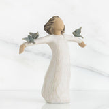 Angel figurine with outstretched arms holding three birds on a white background