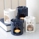 Set of ceramic candle holders with lit candles on a neutral background