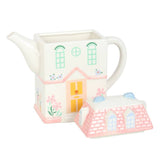Ceramic house-shaped teapot with a matching smaller house-shaped container on a white background