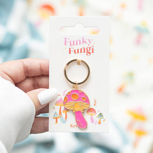 Pink mushroom keychain on a 'Funky Fungi' branded card held by a hand.