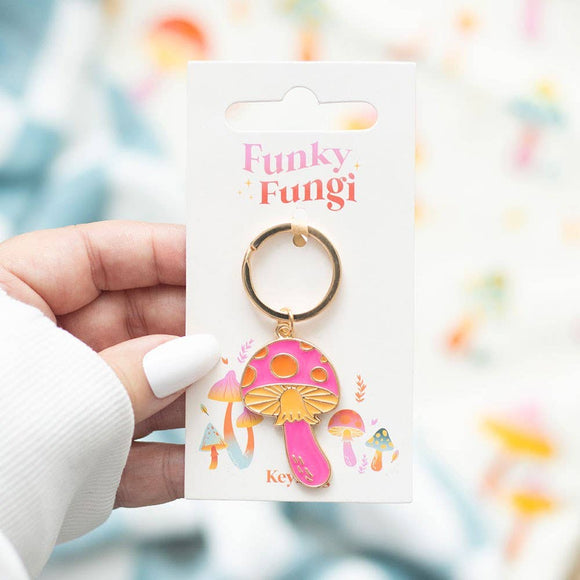 Pink mushroom keychain on a 'Funky Fungi' branded card held by a hand.