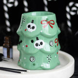 Green mug with decorative patterns on a white surface