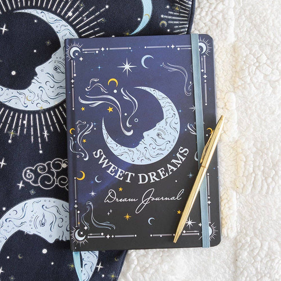 Decorative notebook titled 'Sweet Dreams' with celestial design on a textured surface